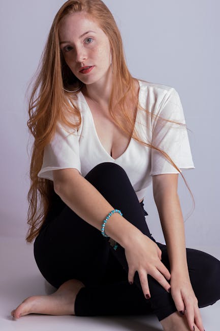 Woman sitting in a simple cross-legged pose with eyes closed, looking serene.